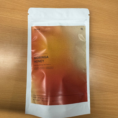 NEKT Moringa Honey white pouch on a wooden table